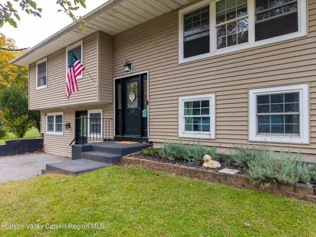 a front view of a house with a yard and outdoor seating