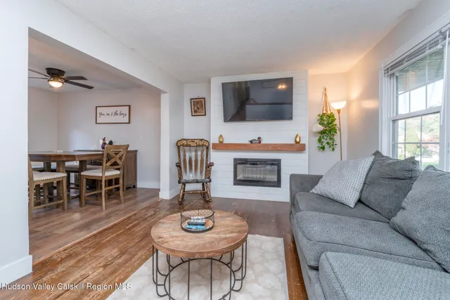 a living room with furniture a flat screen tv and kitchen view