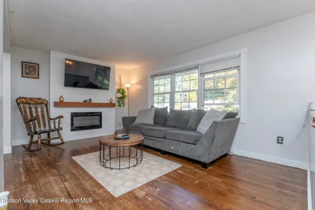 a living room with furniture a flat screen tv and a fireplace