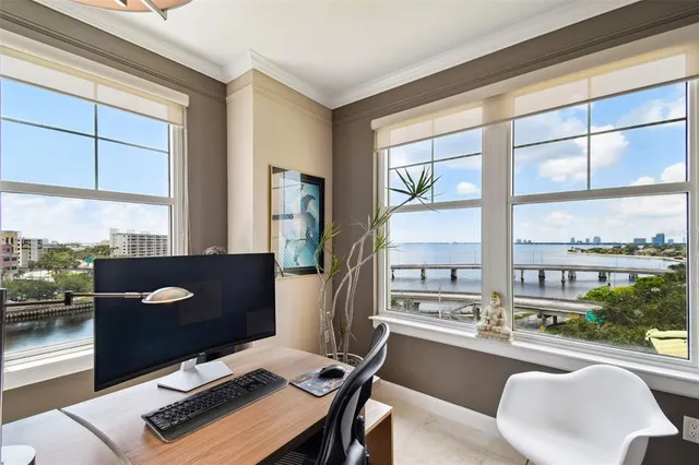 a view of a workspace with furniture and a window