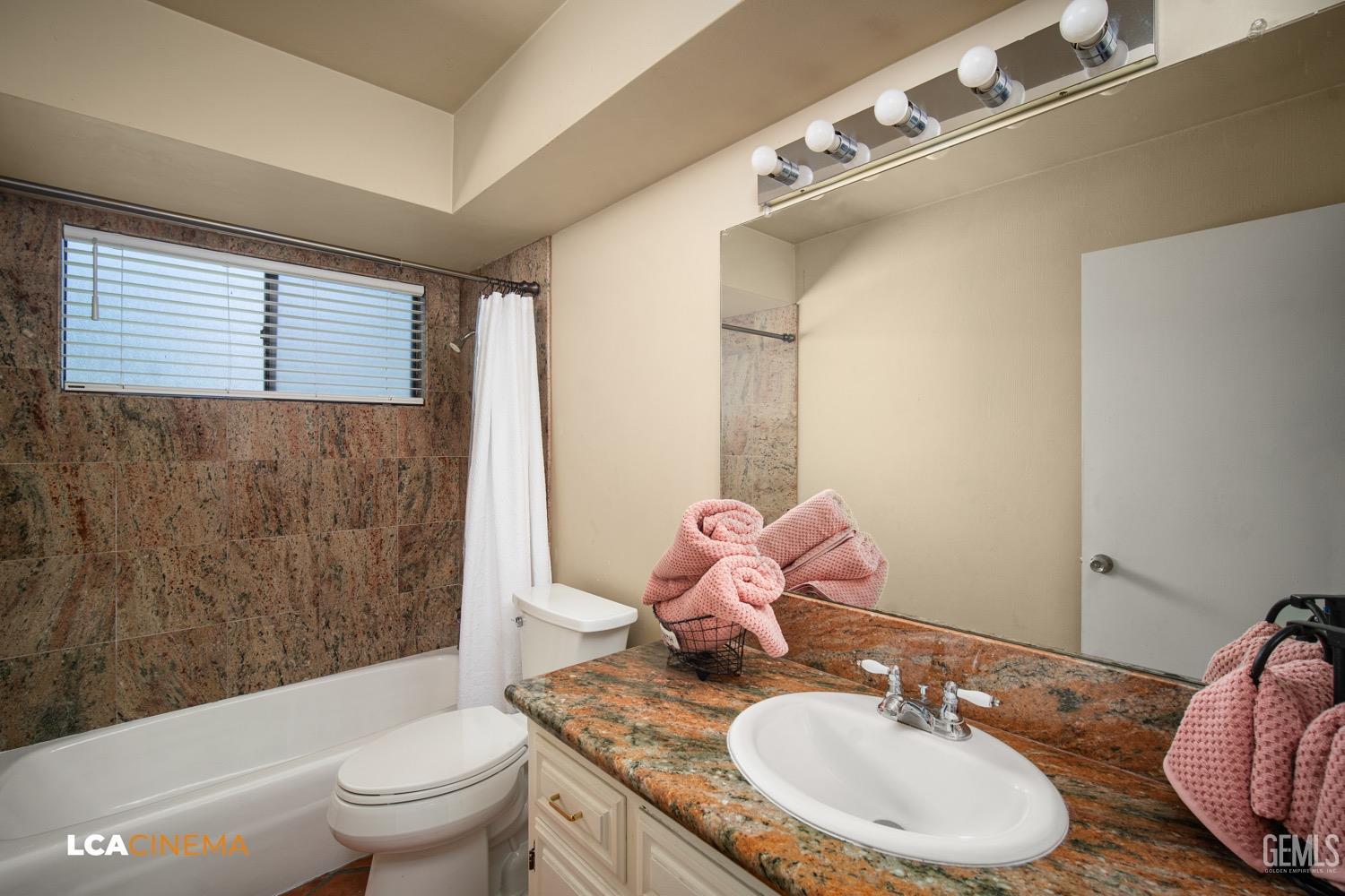 Undisclosed Address Bakersfield, CA 93309 - Photo 14 of 30 a bathroom with a granite countertop sink mirror toilet and bathtub