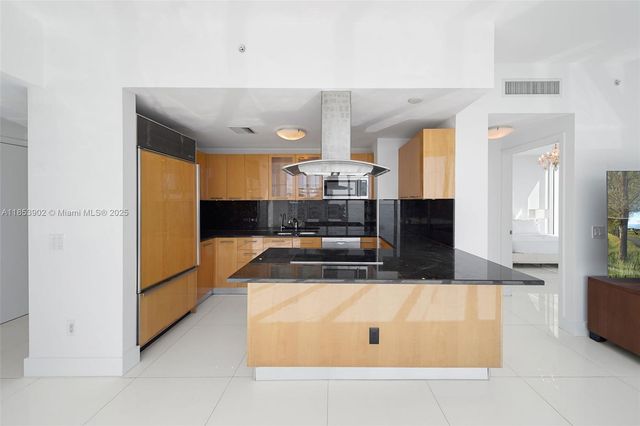 a kitchen with stainless steel appliances granite countertop a sink and a refrigerator