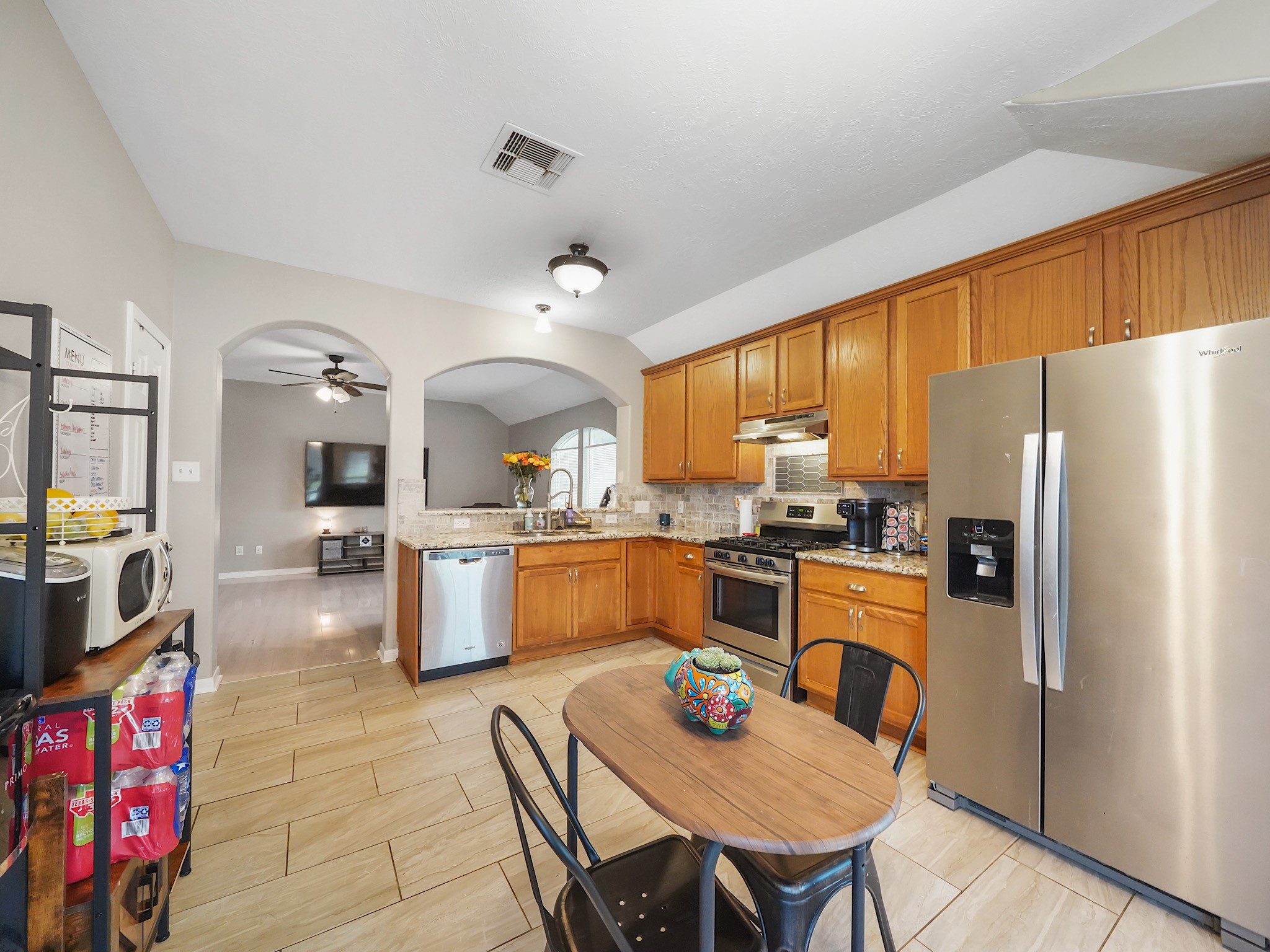 4006 Raspberry Court Dickinson, TX 77539 - Photo 6 of 22 a kitchen with stainless steel appliances kitchen island granite countertop a refrigerator a stove top oven a sink dishwasher and couches with wooden floor