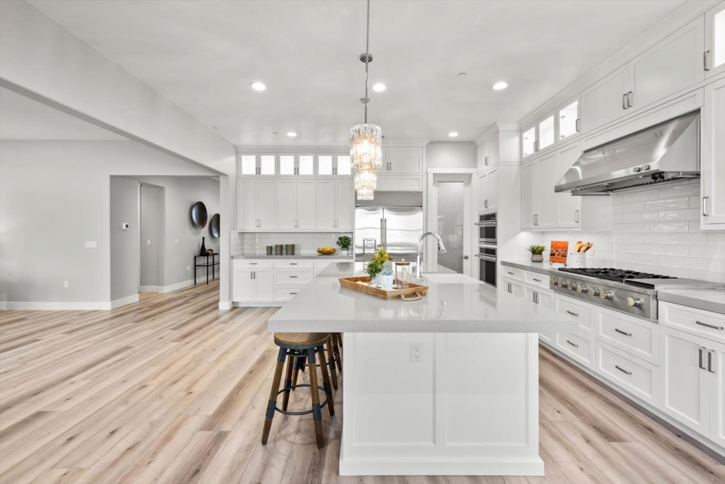 9515 Faria Preserve Parkway San Ramon, CA 94583 - Photo 23 of 84 a kitchen with stainless steel appliances kitchen island granite countertop a stove a sink a refrigerator and white cabinets with wooden floor