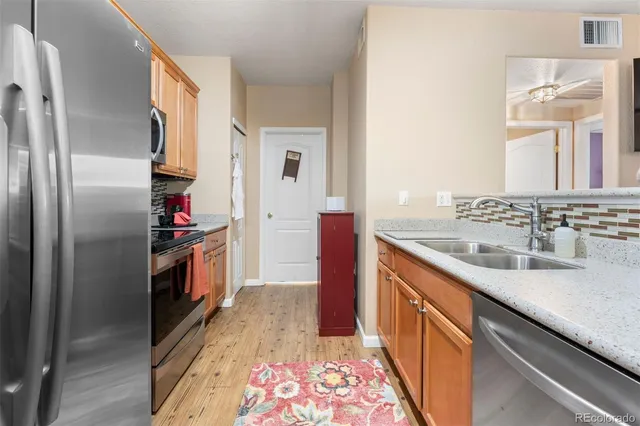 a kitchen with stainless steel appliances granite countertop a refrigerator and a sink