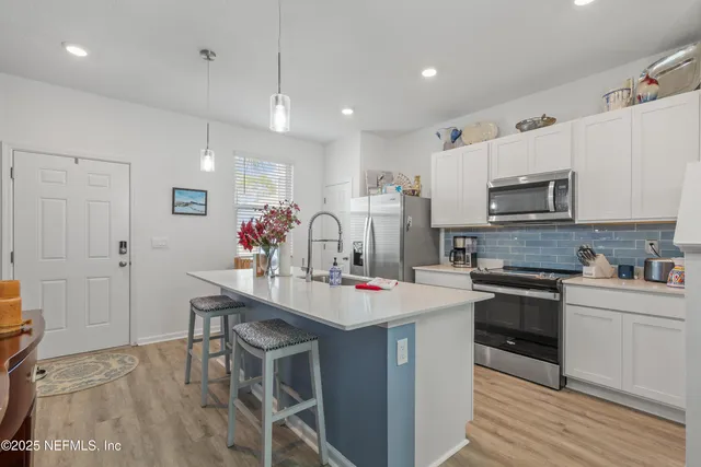 a kitchen with kitchen island granite countertop a stove and a wooden floors
