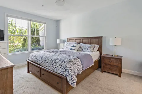 a bedroom with a bed and a large mirror on dresser