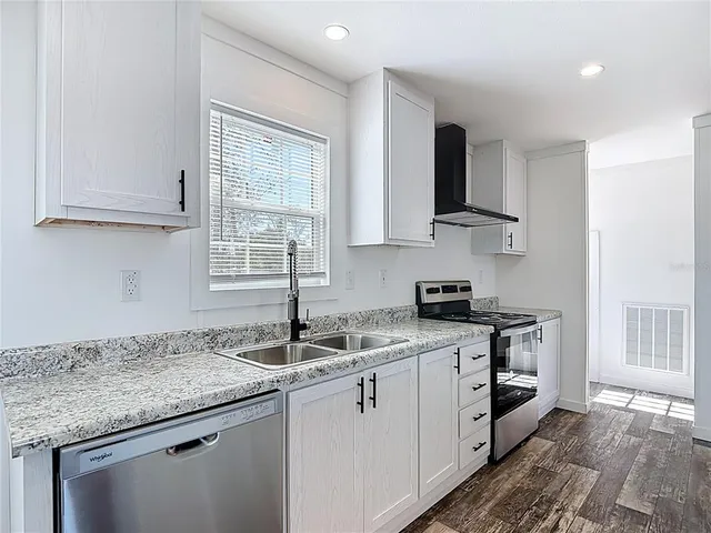 a kitchen with stainless steel appliances granite countertop a sink stove and cabinets