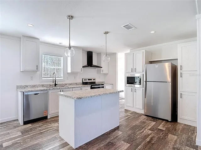 a kitchen with stainless steel appliances granite countertop a refrigerator a stove a sink and a refrigerator