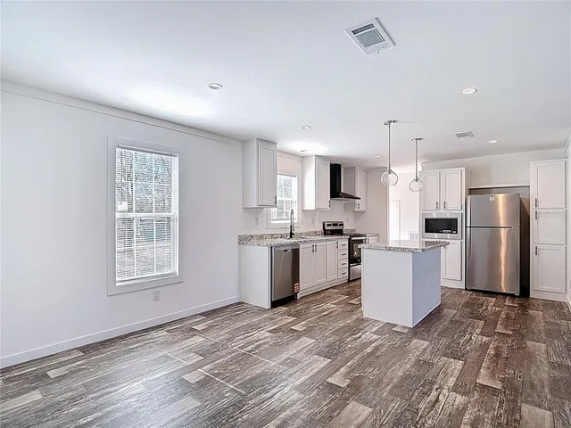 a kitchen with white cabinets and appliances
