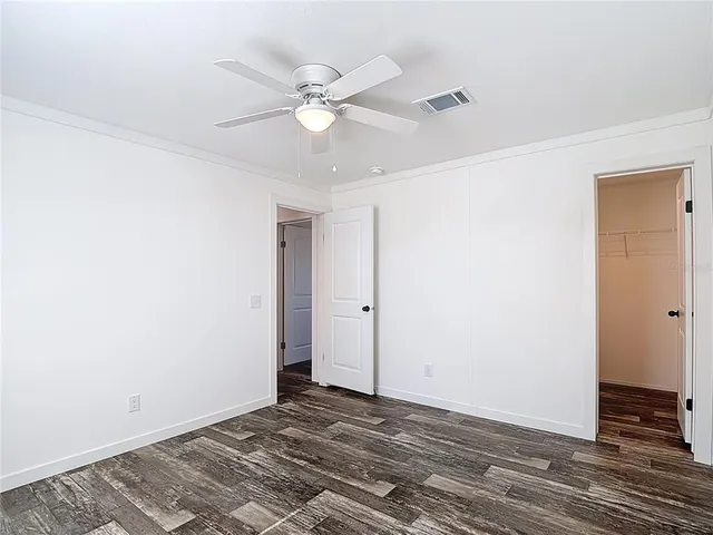 a view of a room with wooden floor and a ceiling fan