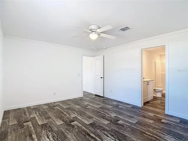 a view of a livingroom with a chandelier fan and wooden floor