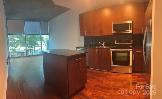 a kitchen with stainless steel appliances granite countertop a stove a sink and a refrigerator