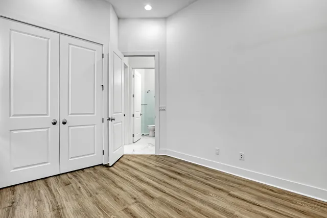 a view of an empty room with wooden floor