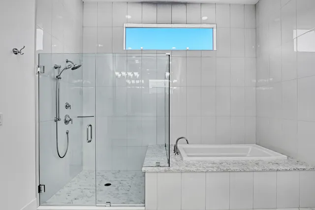 a bathroom with a granite countertop shower a sink and vanity