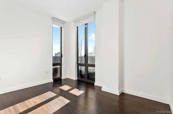 an empty room with wooden floor and window