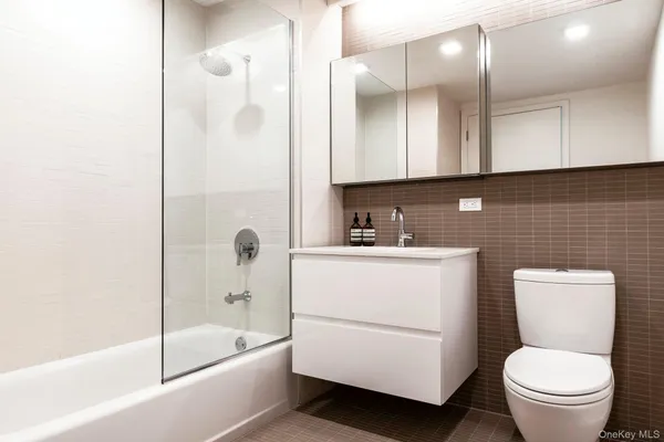 a bathroom with a granite countertop toilet a sink and a bathtub