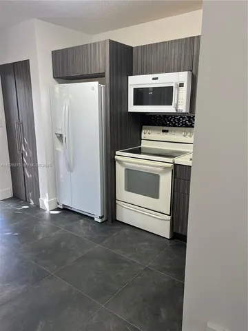a view of kitchen with stainless steel appliances cabinets and a window