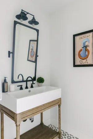 a bathroom with a tub a sink and mirror