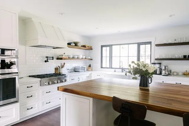 a kitchen with stainless steel appliances granite countertop a sink a stove and cabinets
