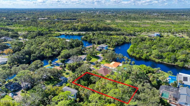 an aerial view of a house with a yard and lake view