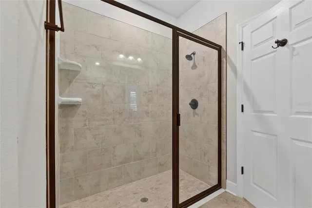 a bathroom with a shower and a glass door
