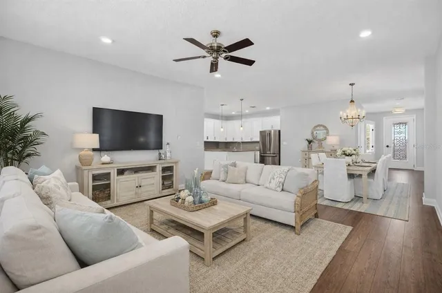 a living room with furniture and a flat screen tv with wooden floor