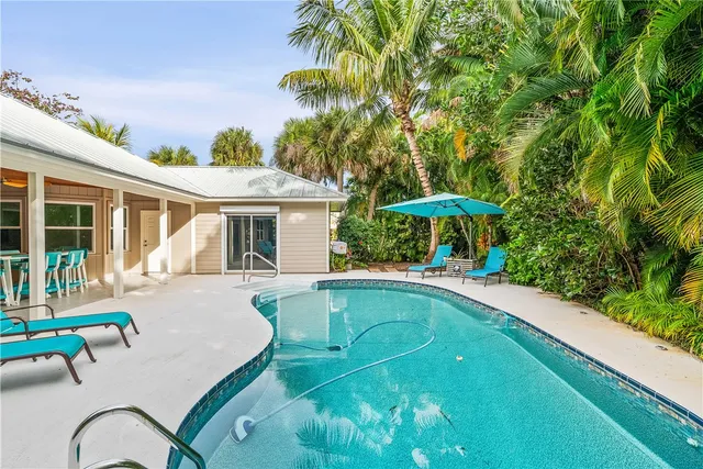a view of a house with swimming pool and sitting area