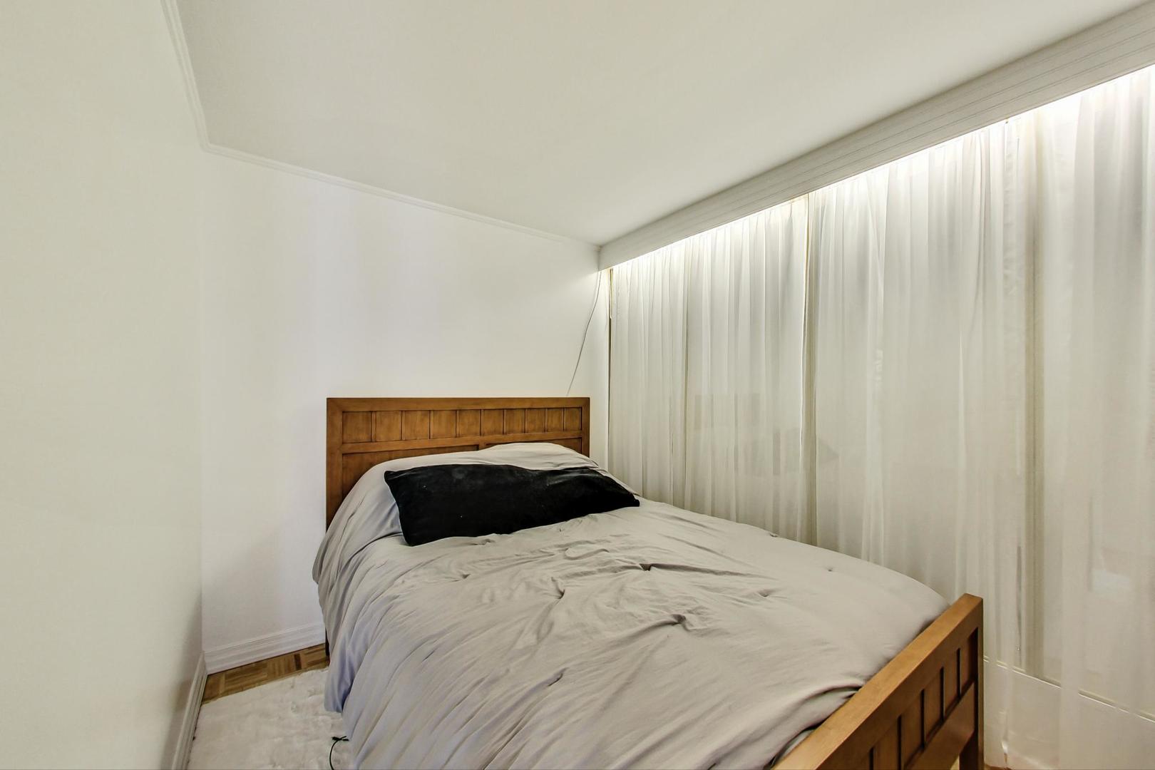 1 East Scott Street, Unit 709 Chicago, IL 60610 - Photo 20 of 31 a bedroom with a bed and curtain