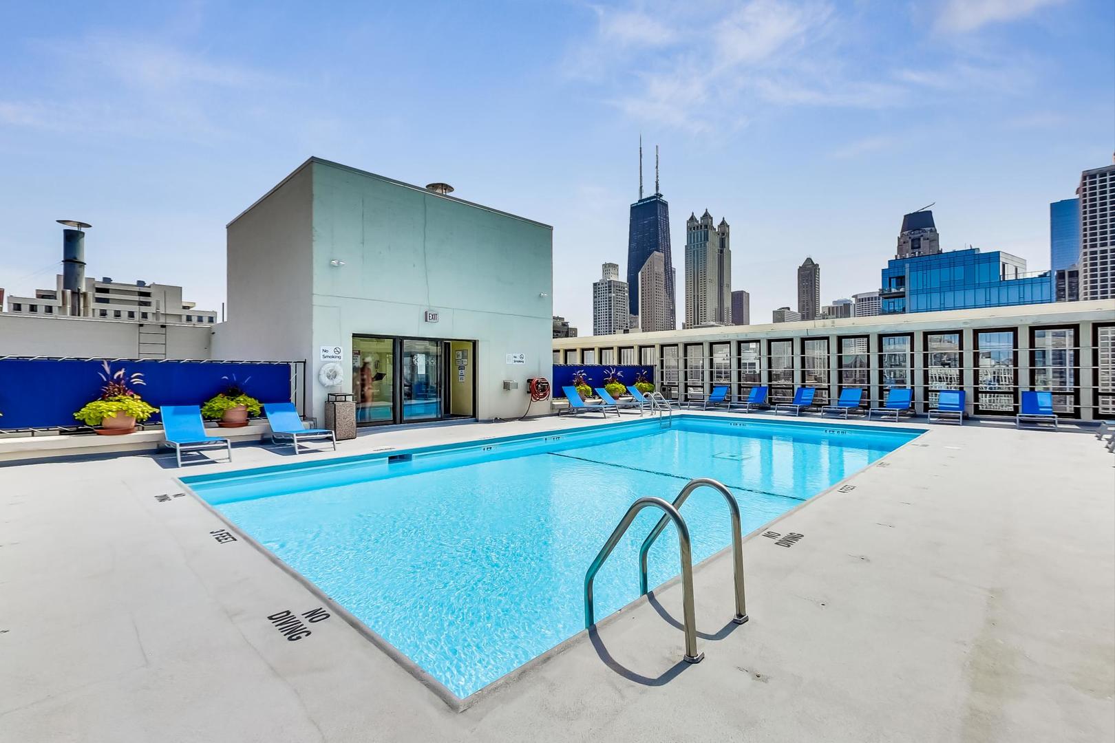 1 East Scott Street, Unit 709 Chicago, IL 60610 - Photo 28 of 31 a view of swimming pool with a lounge chairs and a fire pit