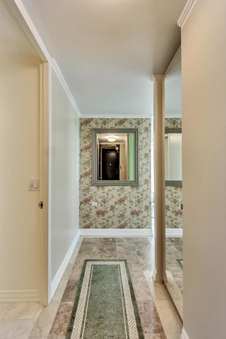 1 East Scott Street, Unit 709 Chicago, IL 60610 - Photo 9 of 31 a view of a hallway with wooden floor a livingroom and front door