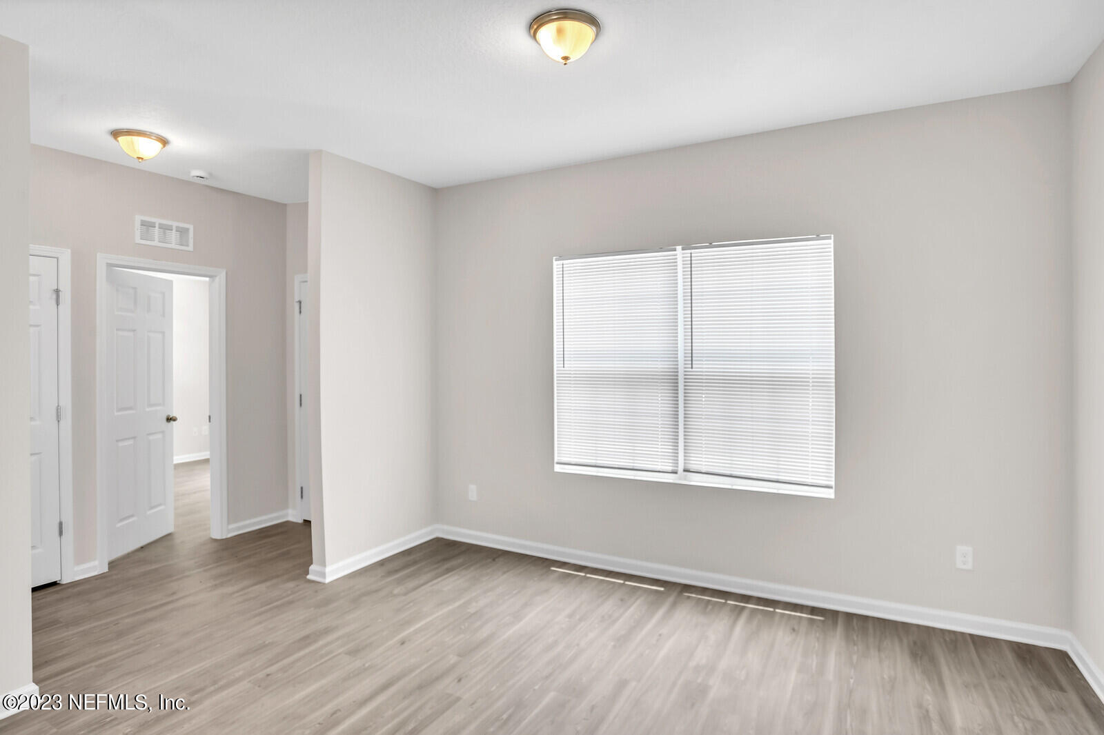 7276 Ridgeway Road North Jacksonville, FL 32244 - Photo 12 of 26 an empty room with wooden floor and windows