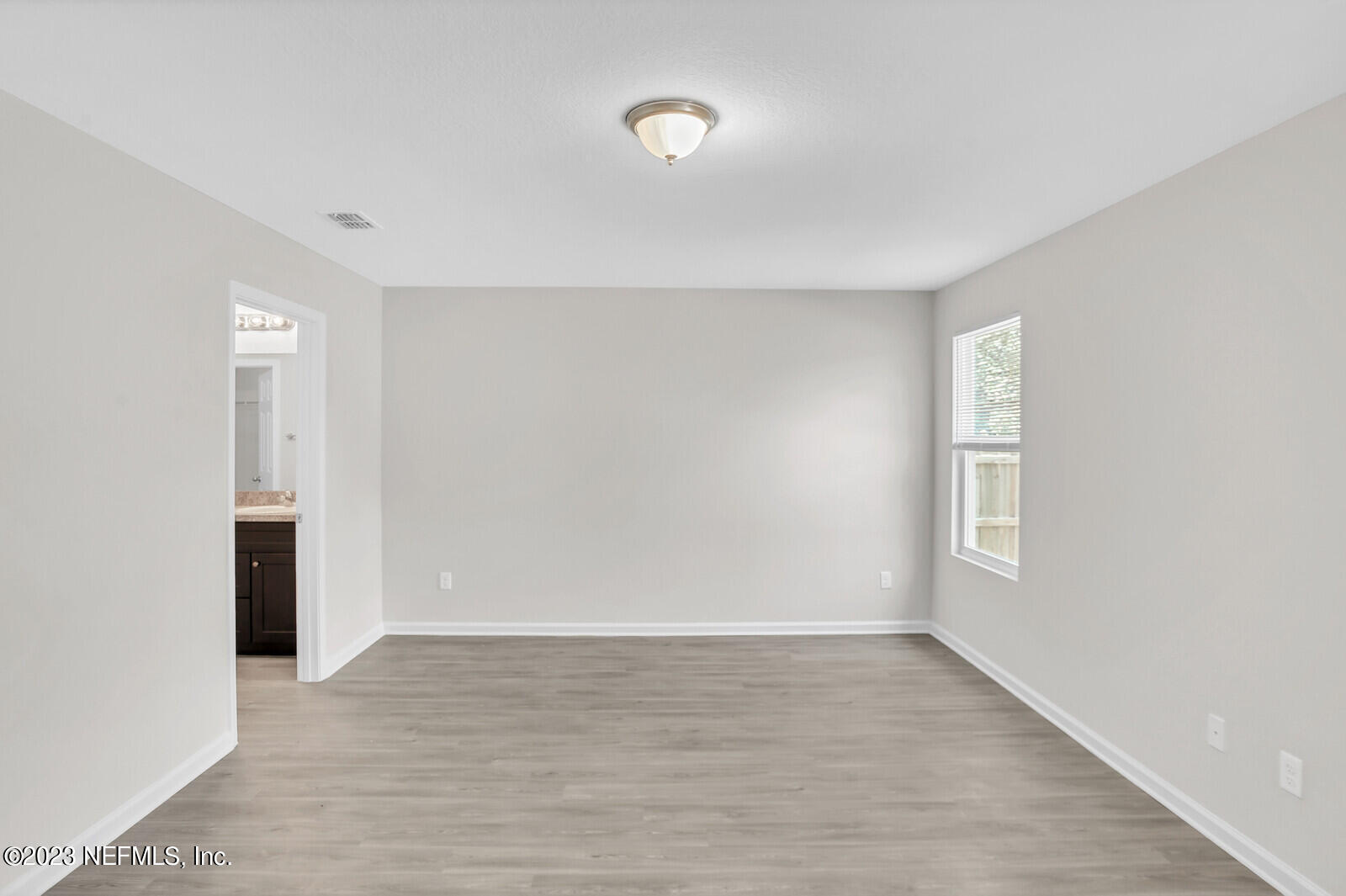 7276 Ridgeway Road North Jacksonville, FL 32244 - Photo 15 of 26 a view of an empty room with wooden floor and a window