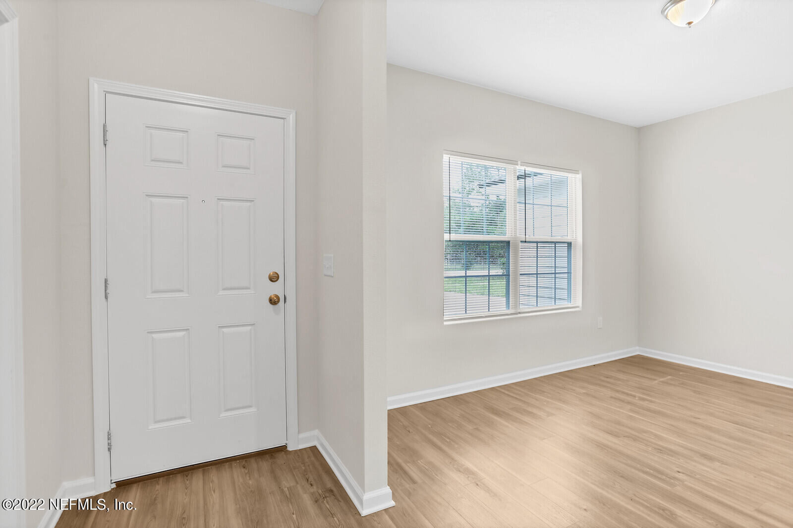 7276 Ridgeway Road North Jacksonville, FL 32244 - Photo 2 of 26 an empty room with wooden floor and windows