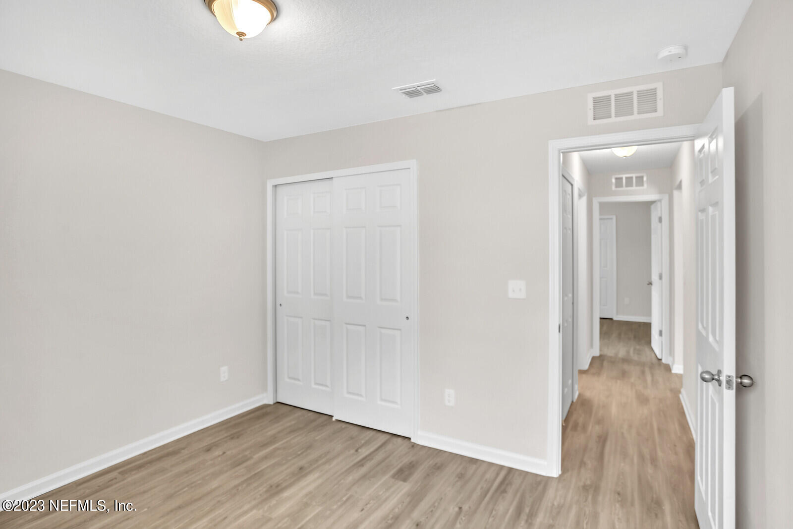 7276 Ridgeway Road North Jacksonville, FL 32244 - Photo 23 of 26 an empty room with wooden floor and windows