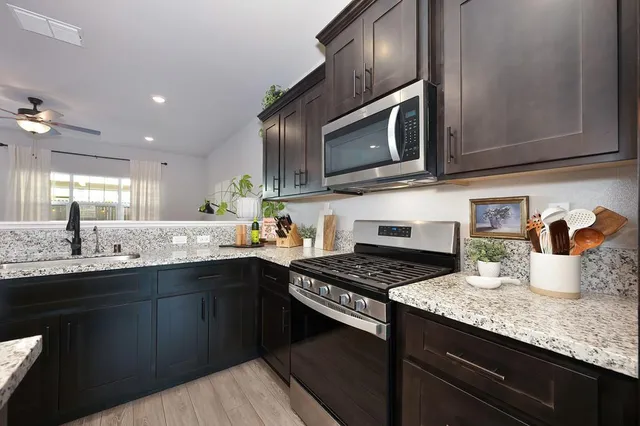 a kitchen with stainless steel appliances granite countertop a sink and stove top oven