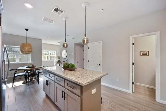 a kitchen with granite countertop appliances cabinets dining table and chairs