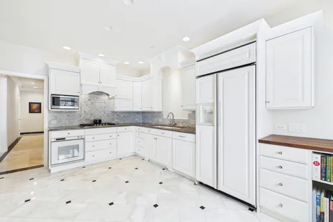 a kitchen with granite countertop white cabinets and white appliances