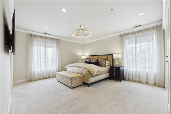 a bedroom with a bed and a chandelier