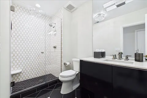 a bathroom with a toilet sink shower and mirror
