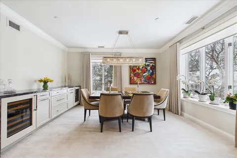 a dining room with furniture a chandelier and window