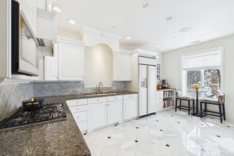 a kitchen with granite countertop a sink stove and refrigerator