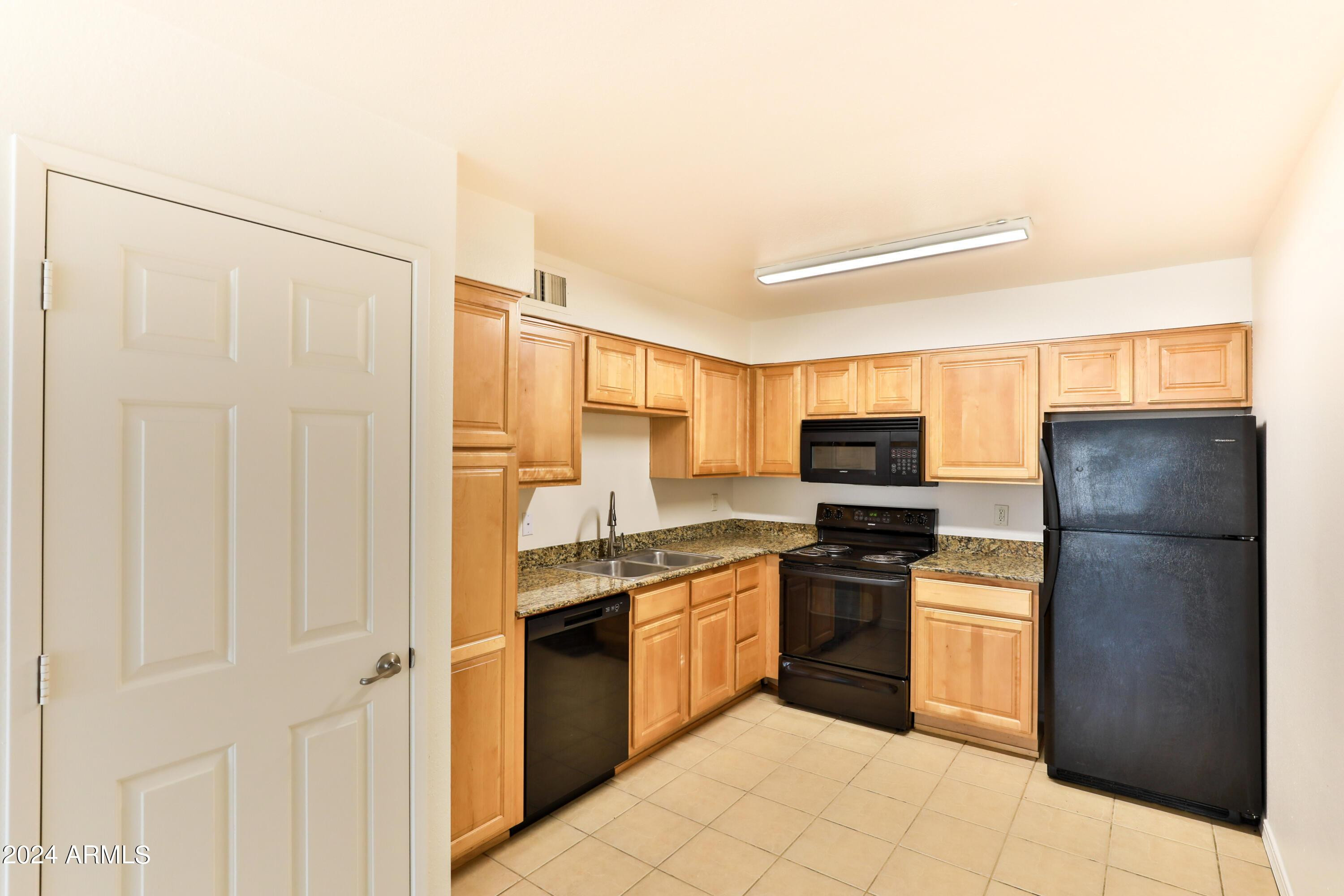 330 South Beck Avenue, Unit 201 Tempe, AZ 85281 - Photo 7 of 17 a kitchen with a refrigerator a stove and cabinets