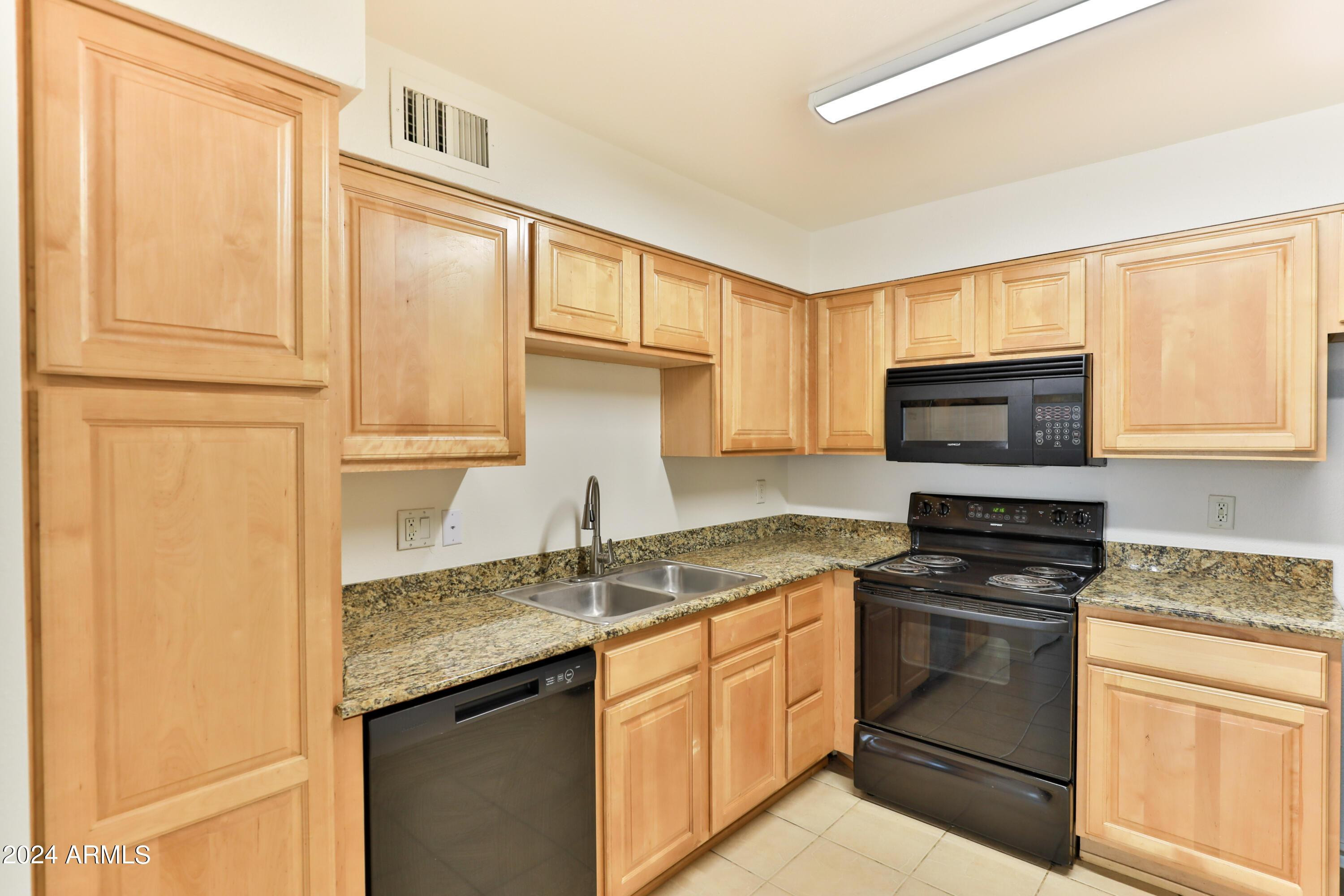 330 South Beck Avenue, Unit 201 Tempe, AZ 85281 - Photo 8 of 17 a kitchen with granite countertop cabinets stainless steel appliances and a sink