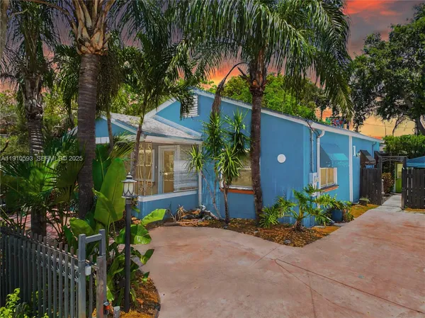 a front view of a house with a yard and potted plants
