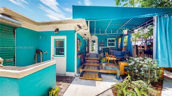 an aerial view of a house with outdoor space and trees in the back
