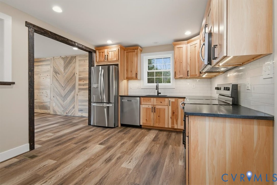 2495 Jackson Shop Road Goochland, VA 23063 - Photo 13 of 38 a kitchen with stainless steel appliances granite countertop a refrigerator a sink and wooden floors