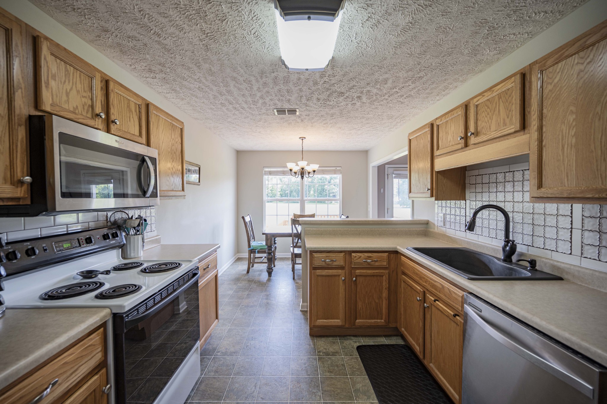 1237 Macduff Drive Murfreesboro, TN 37128 - Photo 7 of 20 a kitchen with stainless steel appliances a sink stove and cabinets
