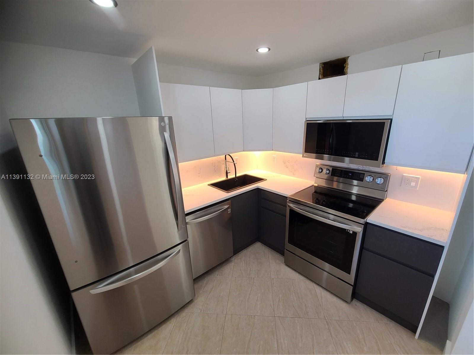 1612 Jefferson Avenue, Unit 403 Miami Beach, FL 33139 - Photo 5 of 55 a kitchen with a refrigerator stove and microwave