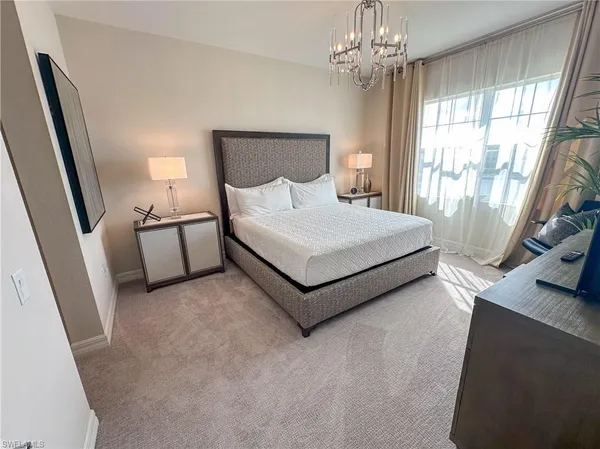 a bedroom with a large bed and a chandelier